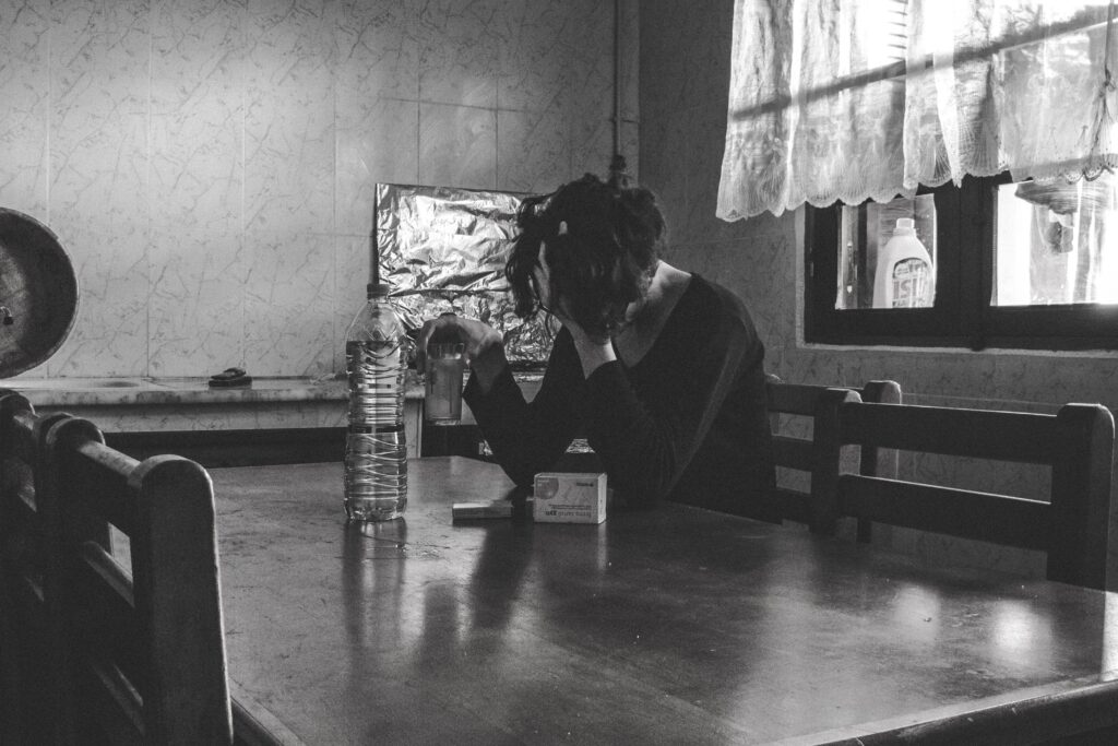 upset, drug addicted woman sitting at a table