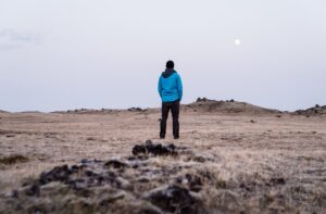 Man standing in a field looking at the moon