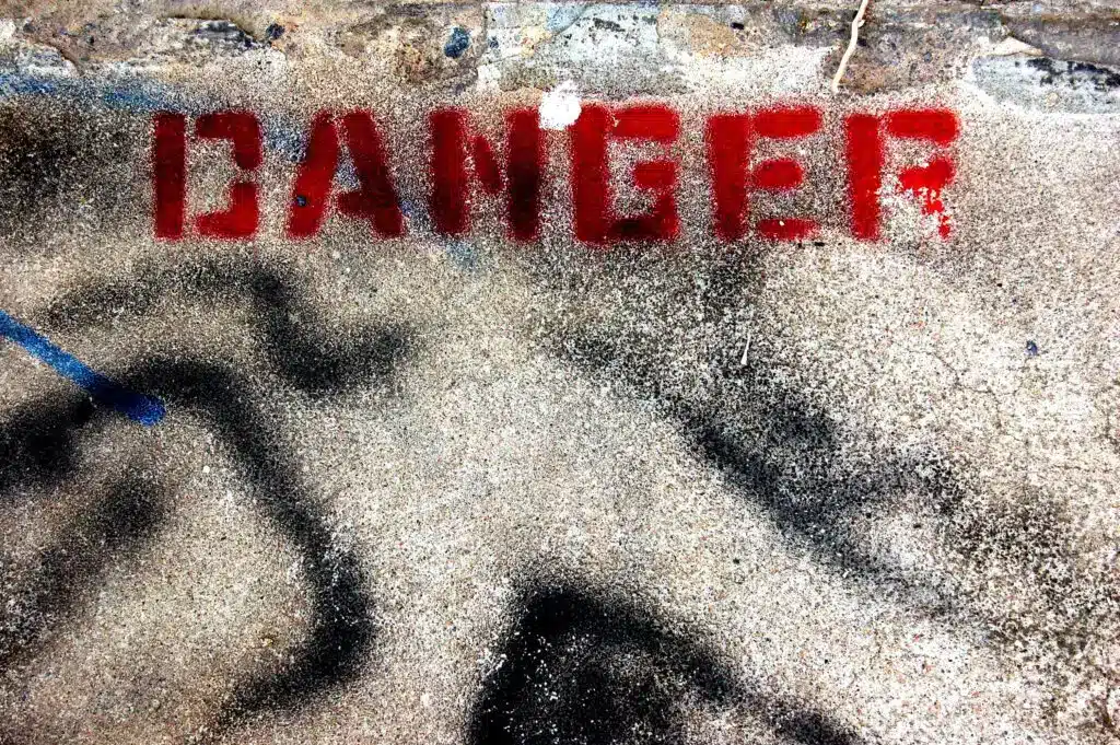 the word "danger" graffiti on the ground