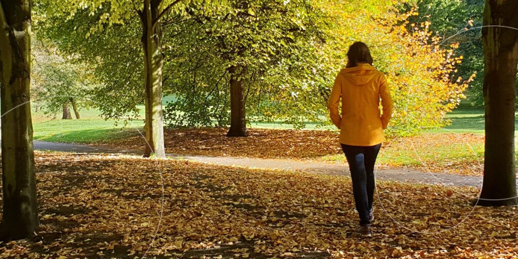 person walking in fall meadow