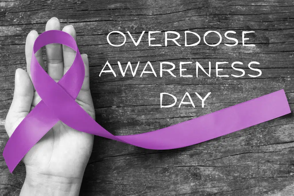 Overdose Awareness Day with hand holding a purple ribbon