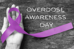Overdose Awareness Day with hand holding a purple ribbon